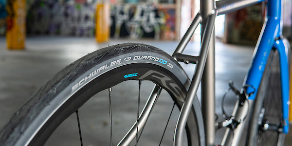 Rear Shimano wheel and Schwalbe tyre detail on a custom-made titanium Curve Belgie bicycle
