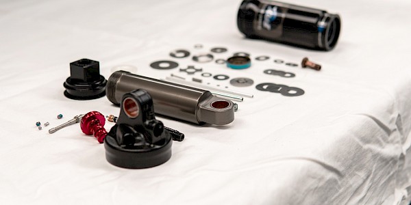 A disassembled bicycle rear shock during the suspension servicing process
