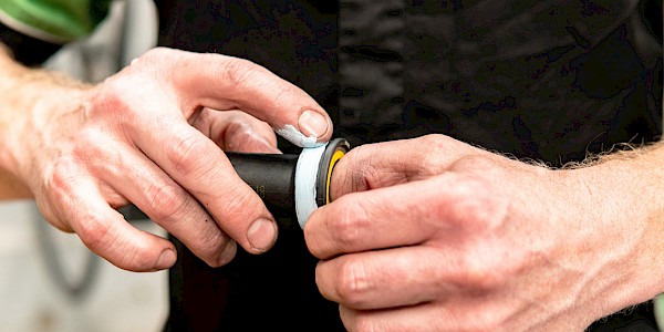 Bicycle mechanic applying custom grease to a bicycle bottom bracket prior to installation