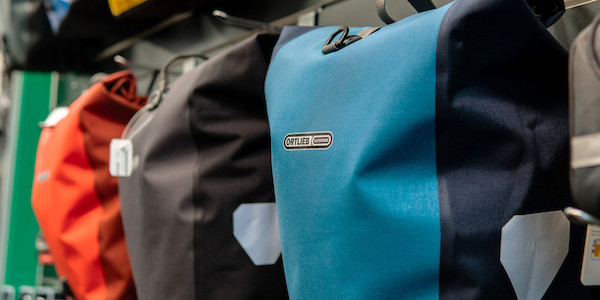 Close-up of a range of Ortlieb Back-Roller Plus panniers in Denim Blue, Graphite and Red Chilli
