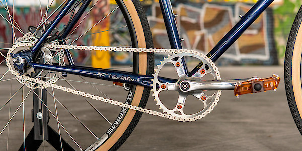 Chain ring, crank and pedals with orange accents, shown on a Surly Straggler bike in Blueberry Muffintop