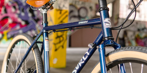 Frame detail on a custom Surly Straggler bicycle in Blueberry Muffintop, graffiti in the background