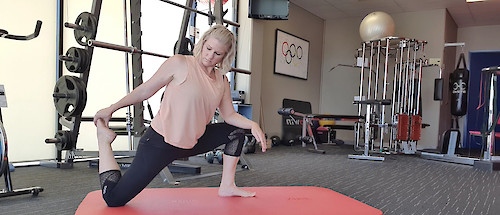 Stretch therapist Holly Hicks demonstrating a kneeling quadriceps stretch.