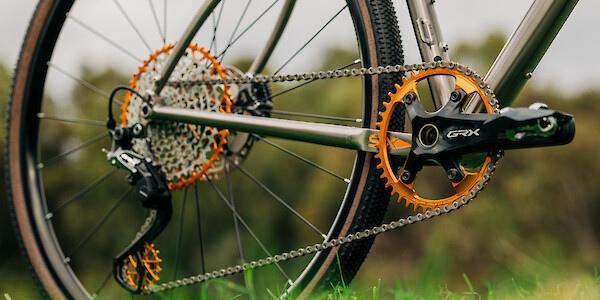 Garbaruk bicycle components in orange, fitted to a titanium gravel bike