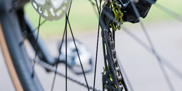 Rear derailleur on a custom Bossi Grit SX bicycle, viewed from the left to show the green Garbaruk pulley wheels