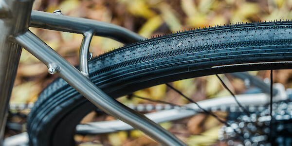 Rear tyre and frame detail on a titanium Bossi Grit gravel bike