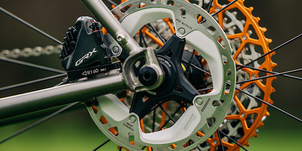 Custom-built Bossi Grit titanium bicycle, GRX disc brake detail plus a rear view of an orange Garbaruk cassette