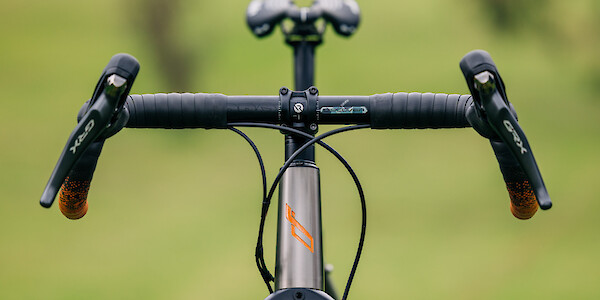 Front view of a Bossi Grit titanium bicycle, showcasing the custom-painted headtube logo
