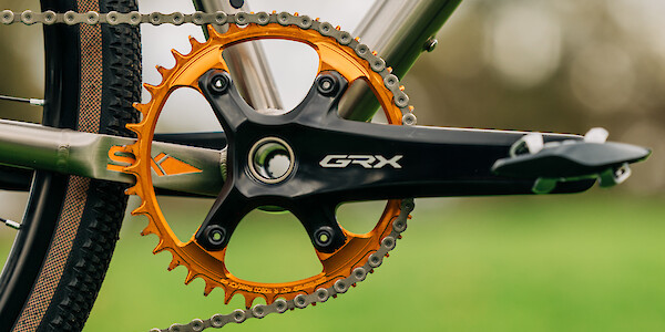 Custom-built Bossi Grit titanium bicycle, close-up detail of the orange Garbaruk chain ring and Shimano GRX crank