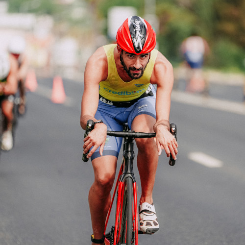 A male road cyclist during a race, looking at the camera