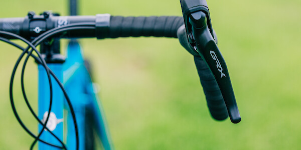 Handlebar and Shimano GRX shifter detail on a blue Genesis Croix de Fer 40 gravel bicycle