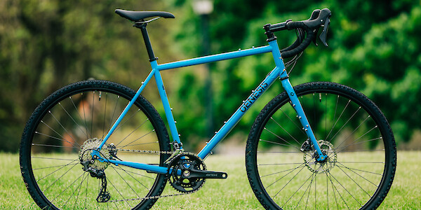 Genesis Croix de Fer 40 gravel bike in blue, against a background of greenery