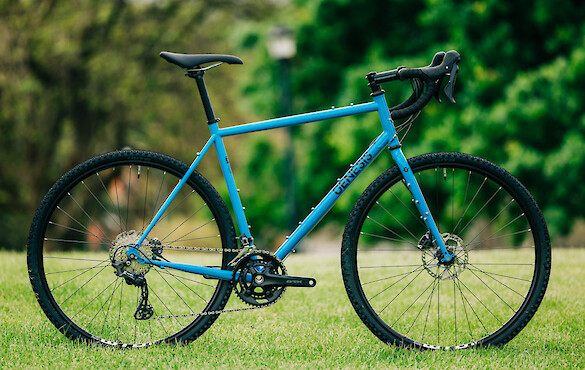 Genesis Croix de Fer 40 gravel bike in blue, against a background of greenery