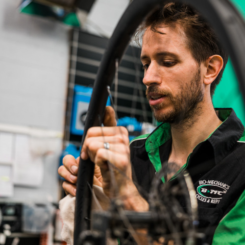 A professional bicycle mechanic, working on a wheel at Bio-Mechanics Cycles & Repairs