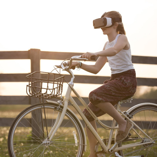 A woman riding a step-through bicycle while wearing a virtual reality headset