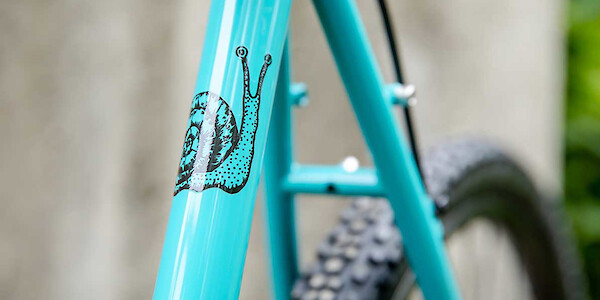 Detail of the snail frame decal on a Surly Straggler bike in Chlorine Dream