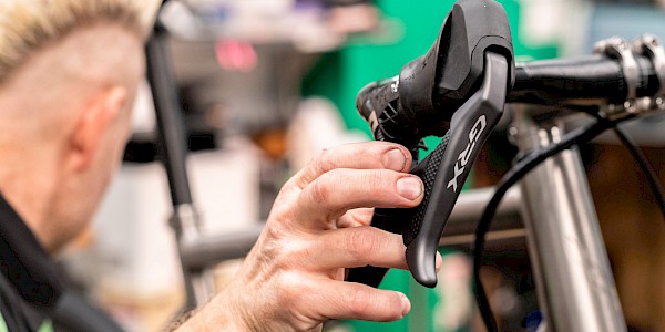 Bicycle mechanic servicing a Shimano GRX shifter