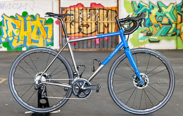 Titanium Curve Belgie with a custom paint job, a colourful graffitied wall in the background
