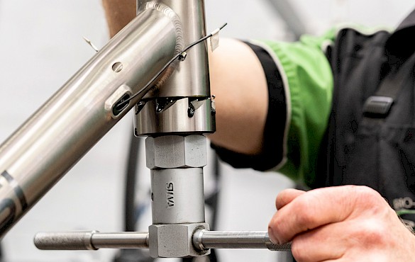 Bicycle mechanic facing and reaming a titanium bicycle frame head tube