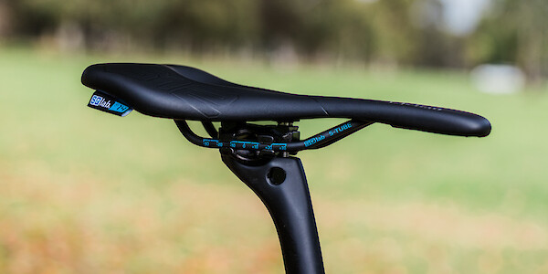 SQLab 612 bicycle saddle fitted to a black seat post, photographed outside, with a green lawn in the background.