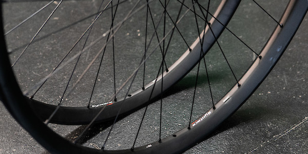 A Syntace wheelset sitting on a black concrete surface