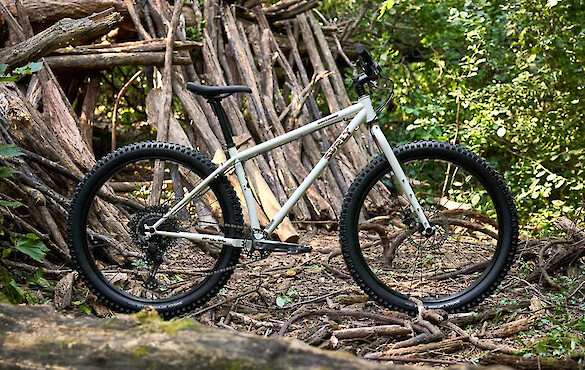 Surly Karate Monkey bike in Snow Mould White, shot against a wooded backdrop