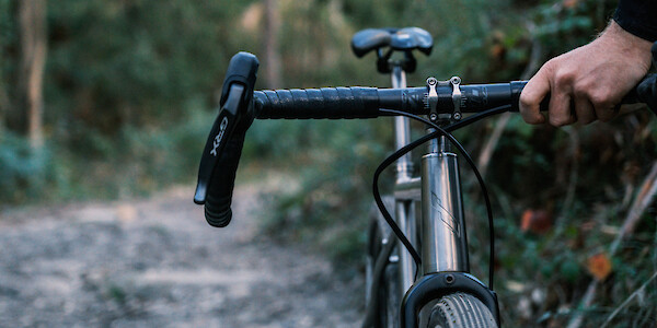 A Bossi Grit SX titanium gravel bike out in the wilds, tenderly held by its owner