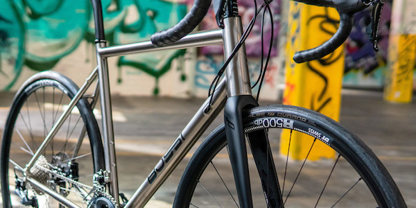 Bossi Summit titanium bicycle, frame detail against a colourful graffiti backdrop