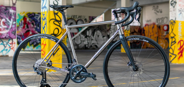 A custom-built Bossi Summit titanium bicycle, in a colourful graffitied car park