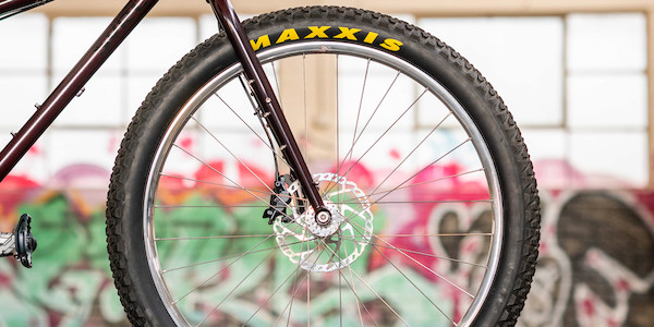 Hand-built mountain bike wheel with silver rim and Maxxis tyre on a Surly Krampus mountain bike
