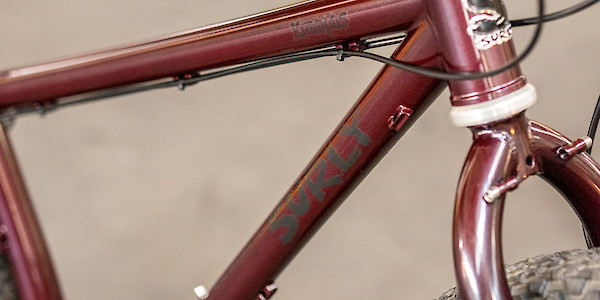 Frame detail of a Surly Krampus mountain bike in Pickled Beet, showing the decals and head badge
