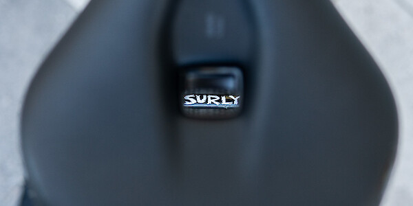 The Surly logo, viewed through the cut-out of an Ergon saddle, on a Surly Ogre touring bicycle