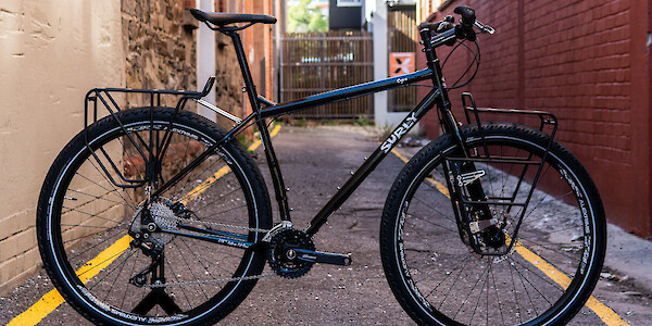 A custom-built black Surly Ogre touring bicycle in a narow alleyway