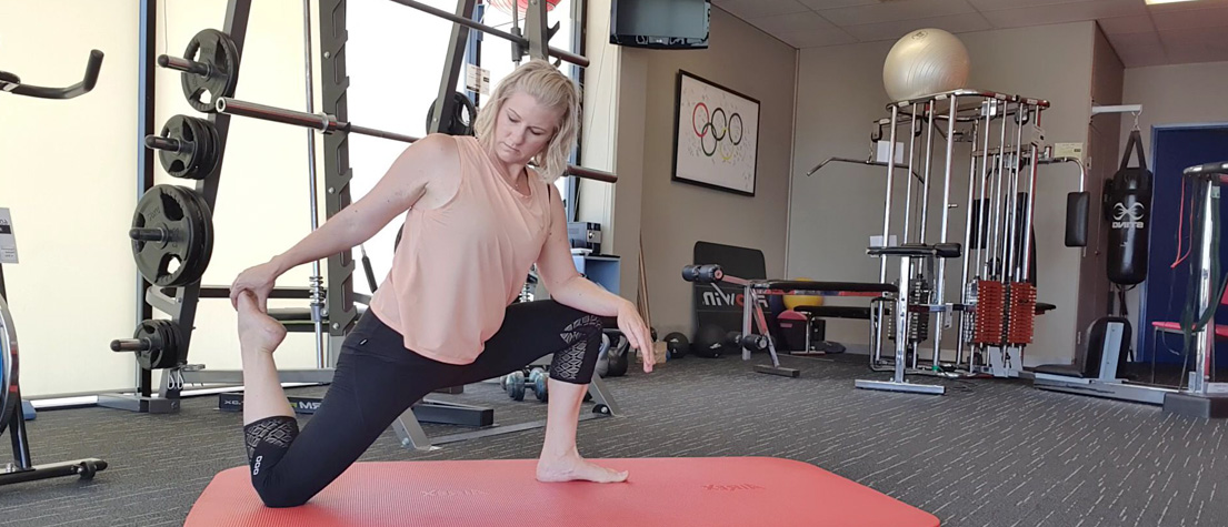 Stretch therapist Holly Hicks demonstrating a kneeling quadriceps stretch.