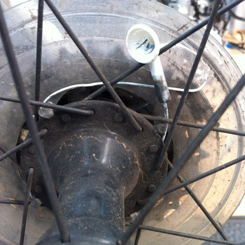 Broken headphones that have wrapped themselves around the rear hub of a bicycle