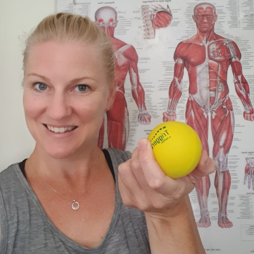 Remedial stretch therapist Holly Hicks holding a yellow trigger ball