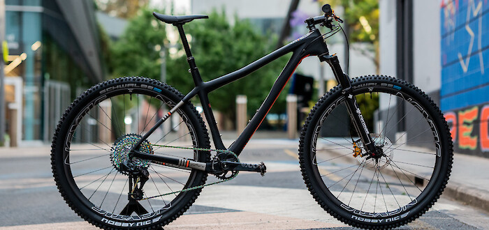 Custom-built Ibis Cycles DV9 carbon hardtail mountain bike, shown in a deserted university campus