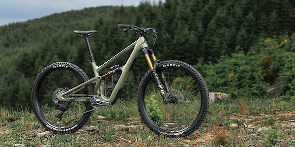 Ibis Ripmo 3 in Olive Swamp Monster green, majestic against the mountain range behind