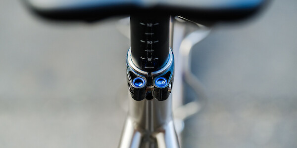 Close-up of a custom-painted seatpost clamp on a titanium Bossi Summit bicycle