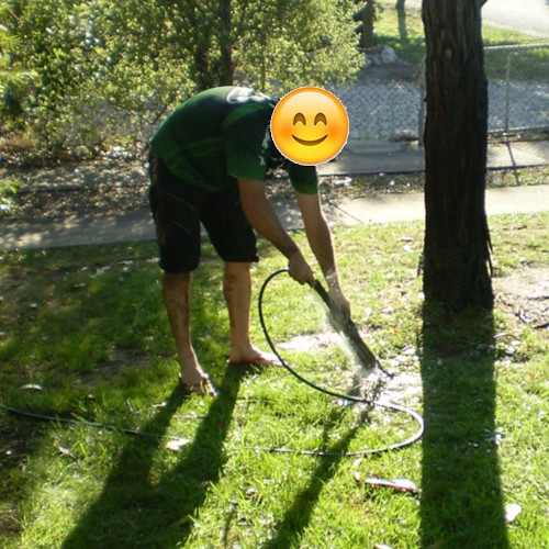 A cyclist (identity obscured) using a hose on a set of bicycle suspension forks, which is not recommended