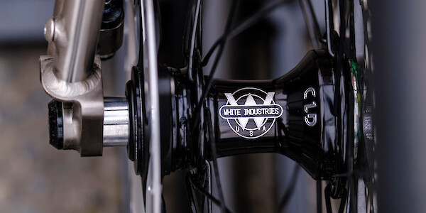 Close-up detail of a White Industries bicycle hub, hand-laced into a carbon rim, fitted to a Bossi Summit titanium frameset