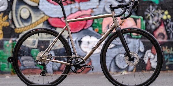 Bossi Summit titanium road bike in a custom build, viewed against a wall of colourful street art
