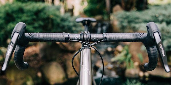 Flared gravel handlebars, viewed from the front, on a custom-built Bossi Grit SX titanium bicycle