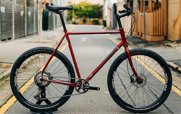 Custom-built Surly Midnight Special bicycle in Strawberry Sparkle, pictured in a back alley