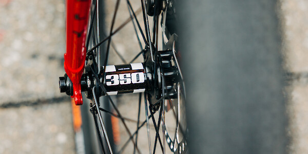 Hand-built wheel with a DT Swiss 350 hub, fitted to a Surly Midnight Special bicycle in Strawberry Sparkle