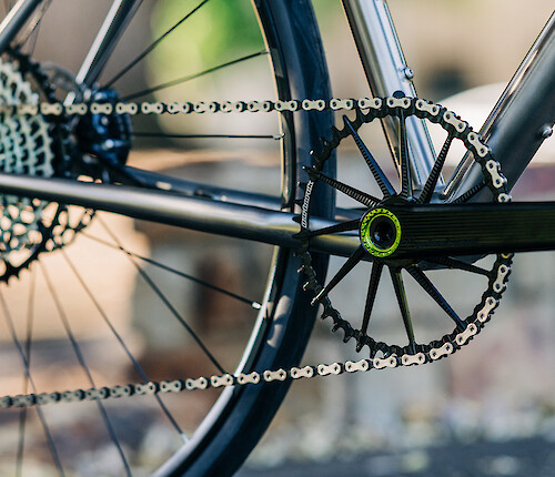Gold Garbaruk drivetrain/gear components fitted to a Time carbon bicycle. A white brick wall is in the background.