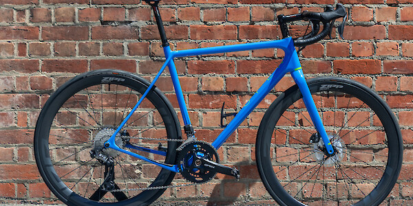 Open Cycles U.P. carbon bike, custom built, viewed against a red brick wall