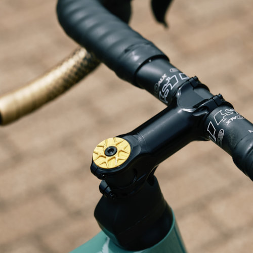A gold Garbaruk top cap fitted to a carbon gravel Gothic Cycles bike