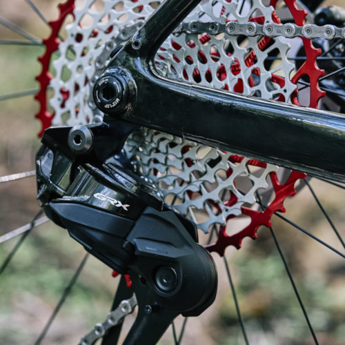 Drivetrain detail of a red Garbaruk cassette, fitted to a carbon Gothic Cycles gravel bike