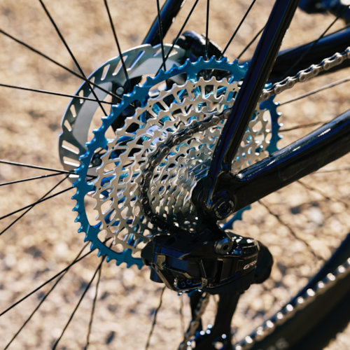 Drivetrain detail of a blue Garbaruk cassette, fitted to a carbon Gothic Cycles gravel bike